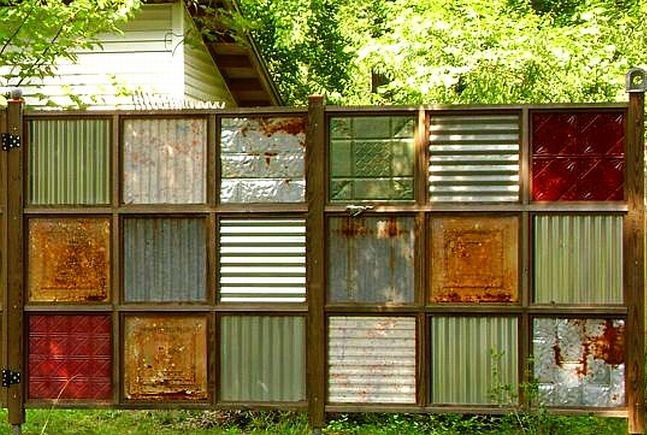 A fence made of recycles items in a square patchwork formation